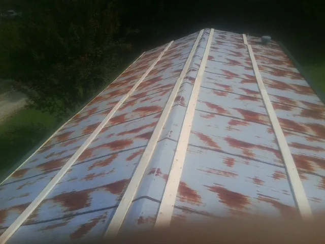 Rusted metal roof panels with new wood purlins before replacement — Storm Damage Roof Repair in Blue Creek by Roofing Brothers
