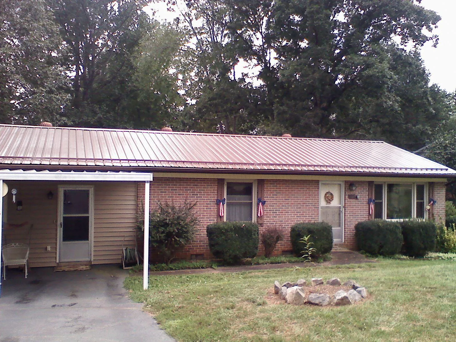 Bronze metal roof and carport on a brick ranch home — Roof Repair work by our crew in Blue Creek