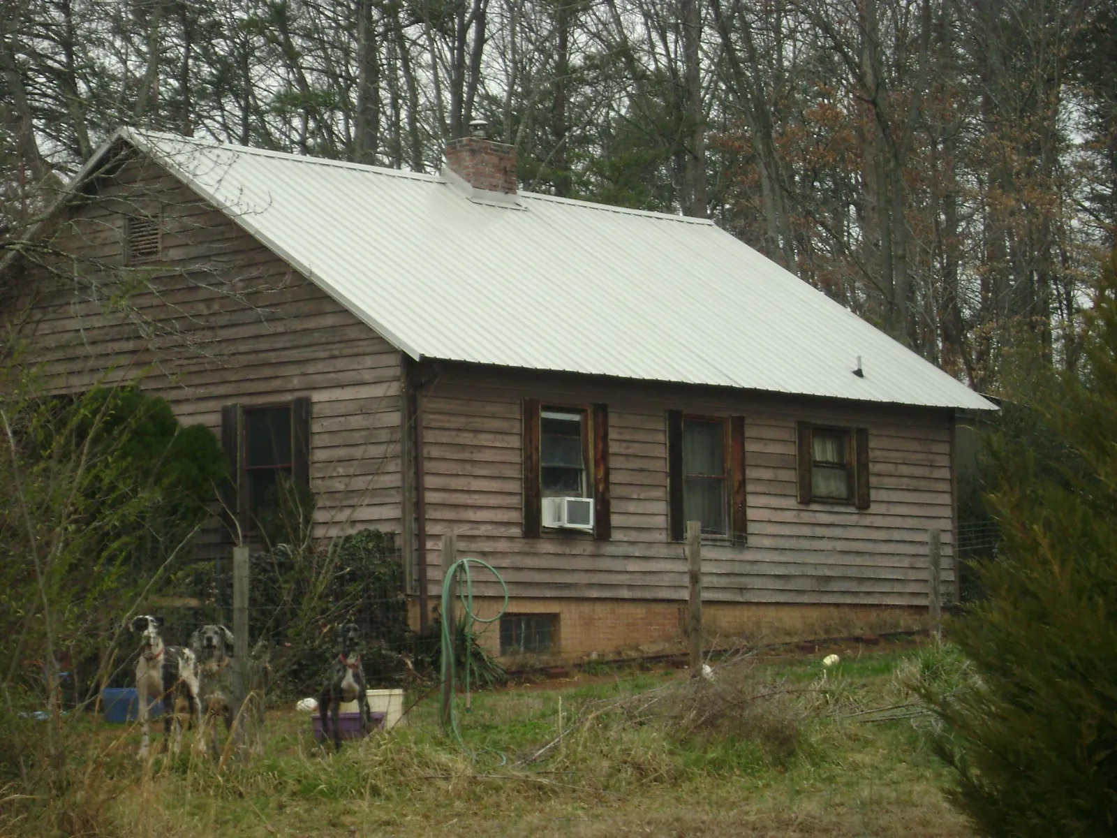 White metal roof on an old wood sided farmhouse, from a Metal Roof Installation job in Blue Creek